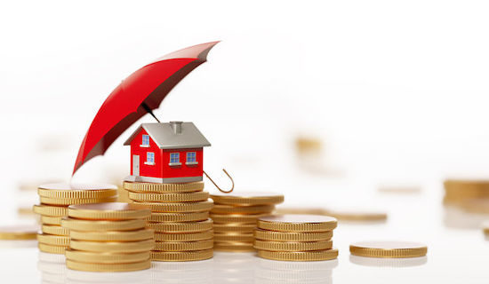 Red Toy House Sitting On White Background Behind Coin Stack: Insurance And Real Estate Concept